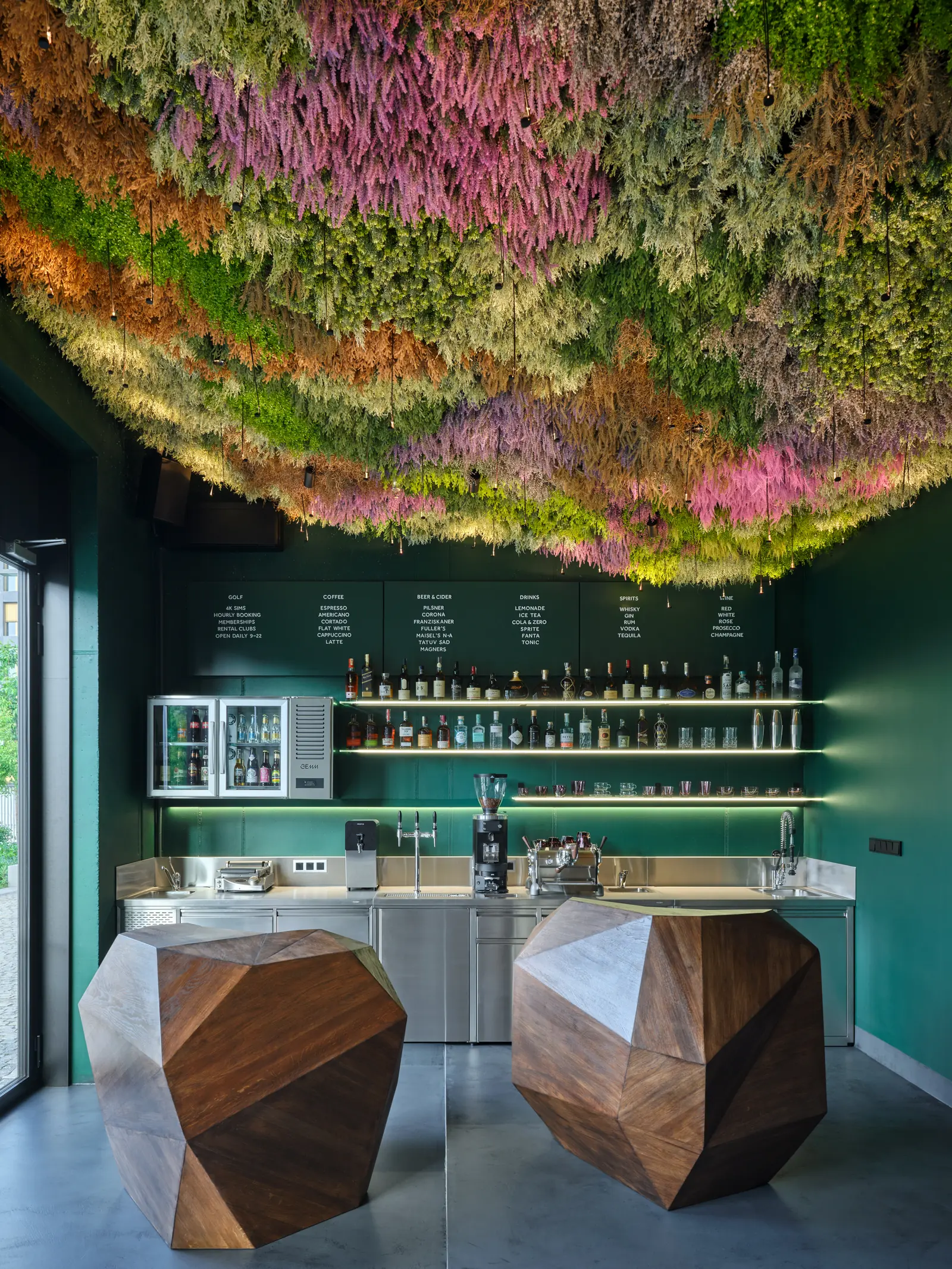 The bar counter with its bottle shelf and a wooden seat in the foreground