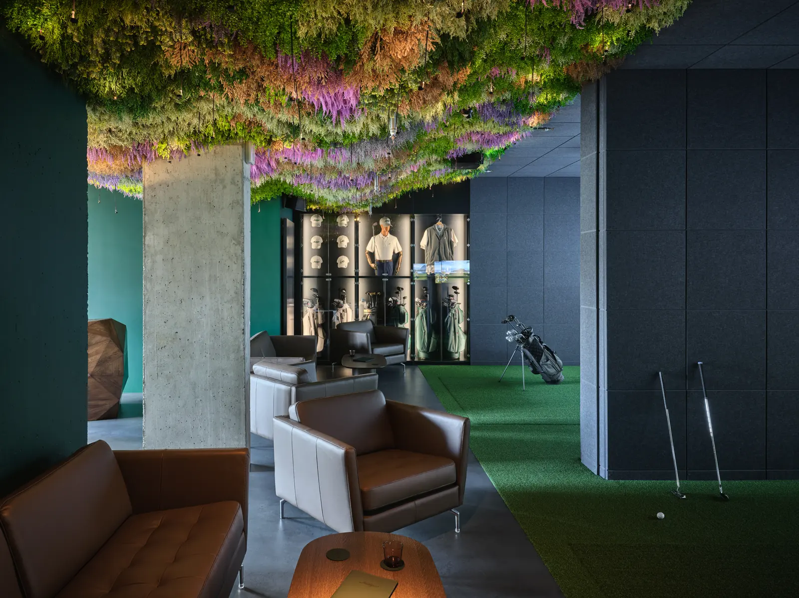 The lounge with leather armchairs, a club rack and the putting turf